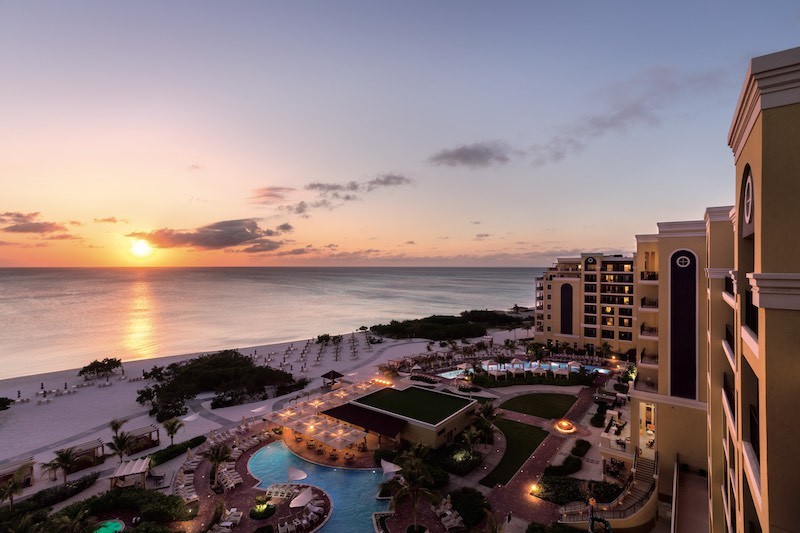 Ritz Carlton Aruba with the sunsetting into the ocean in the background.