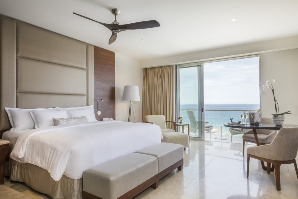 A modern bedroom suite overlooking the ocean.