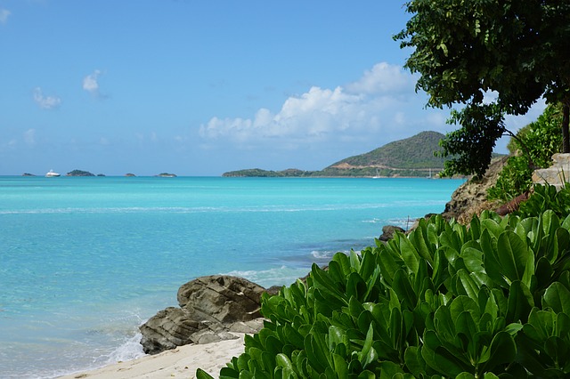 View of the ocean with mountains and ships in the distance.