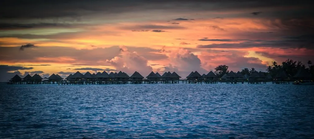 Sunset over Boar Boar overwater bungalows and the ocean.