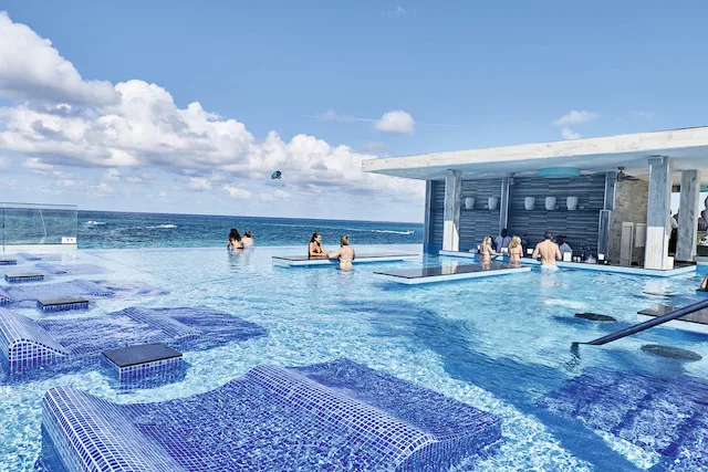 Pool at Riu Palace with in-water lounge chairs and a swin up bar.