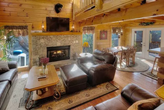 cabin living room with fireplace and view
