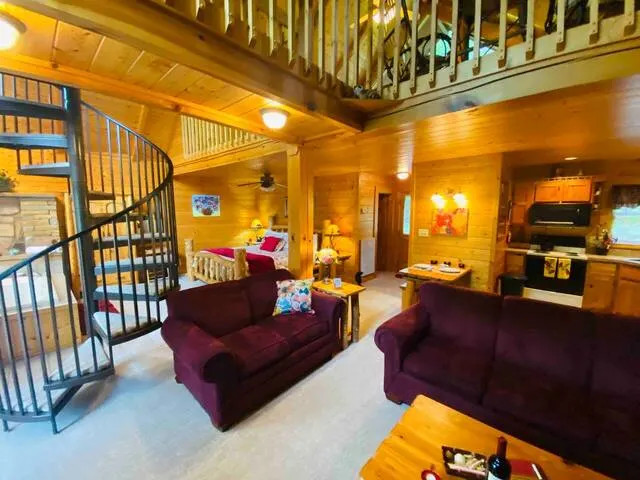 Cabin living room with plush furnature and spiral staircase