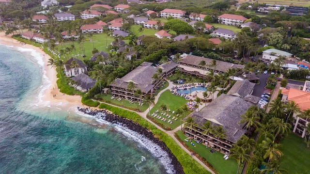 Arial view of Ko'a Kea Hotel and Resort surrounded by buildings and trees.