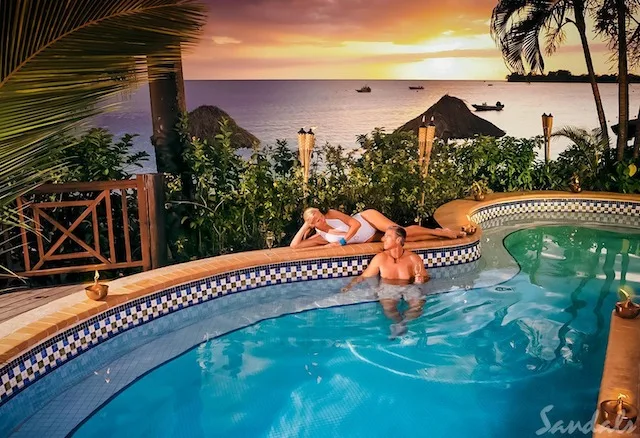 Couple relax in pool at Sandals resort