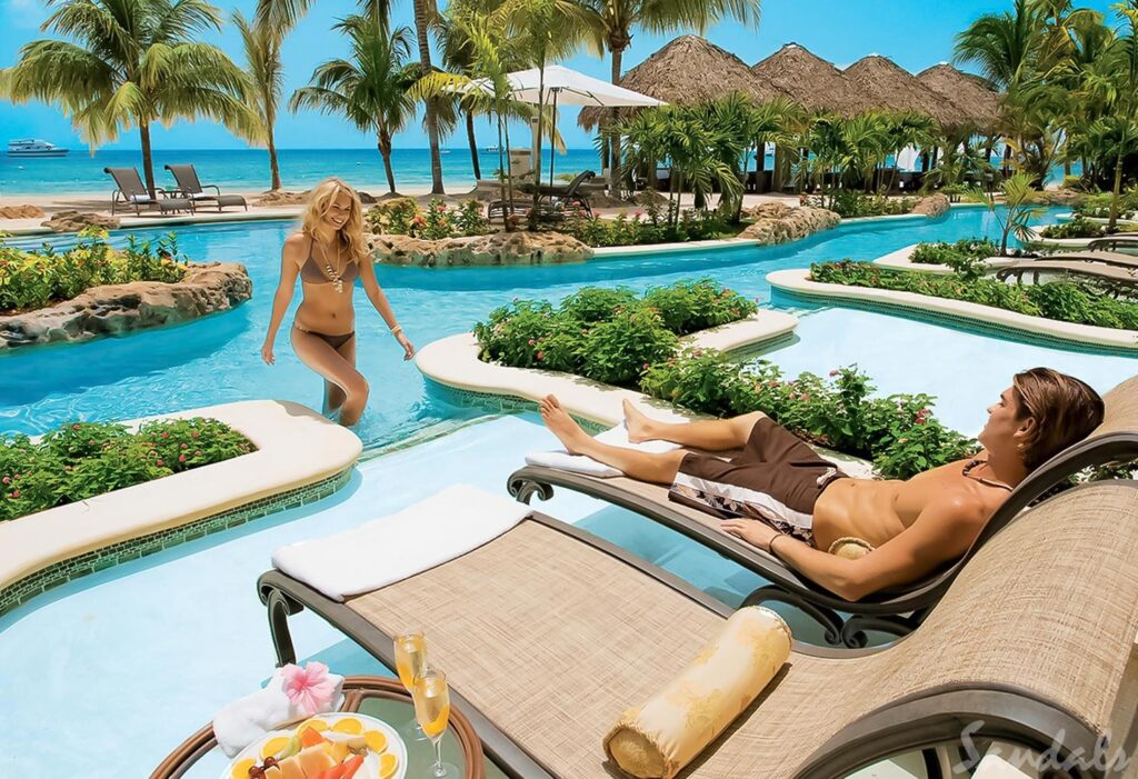 Sandals negril beach resort and spa - a couple enjoys the pool in their swim-up resort suite. 