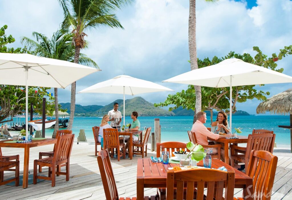 Sandals St. Lucian - couples eating a at a patio restaurant overlooking the ocean