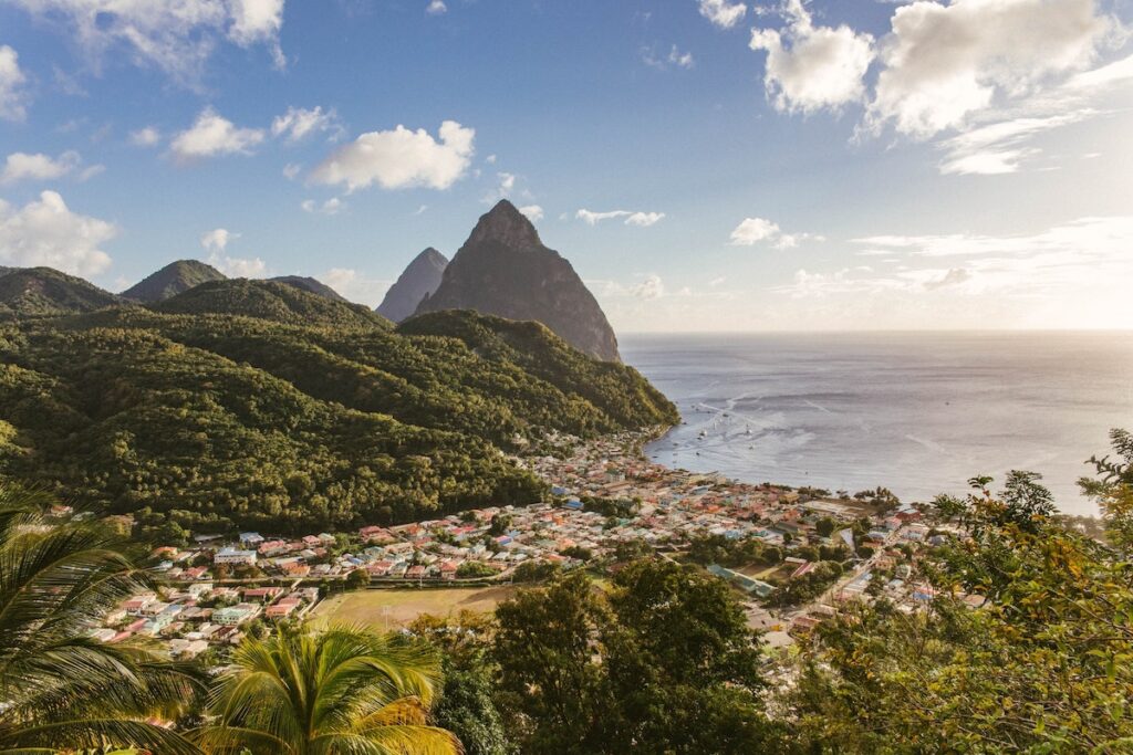 St Lucia landscape with buildings, beach, mountains, and trees.
