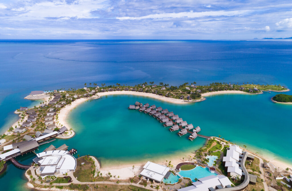 Overwater bungalows at Marriott Momi Bay Resort and Spa Fiji surrounded by clear blue water.