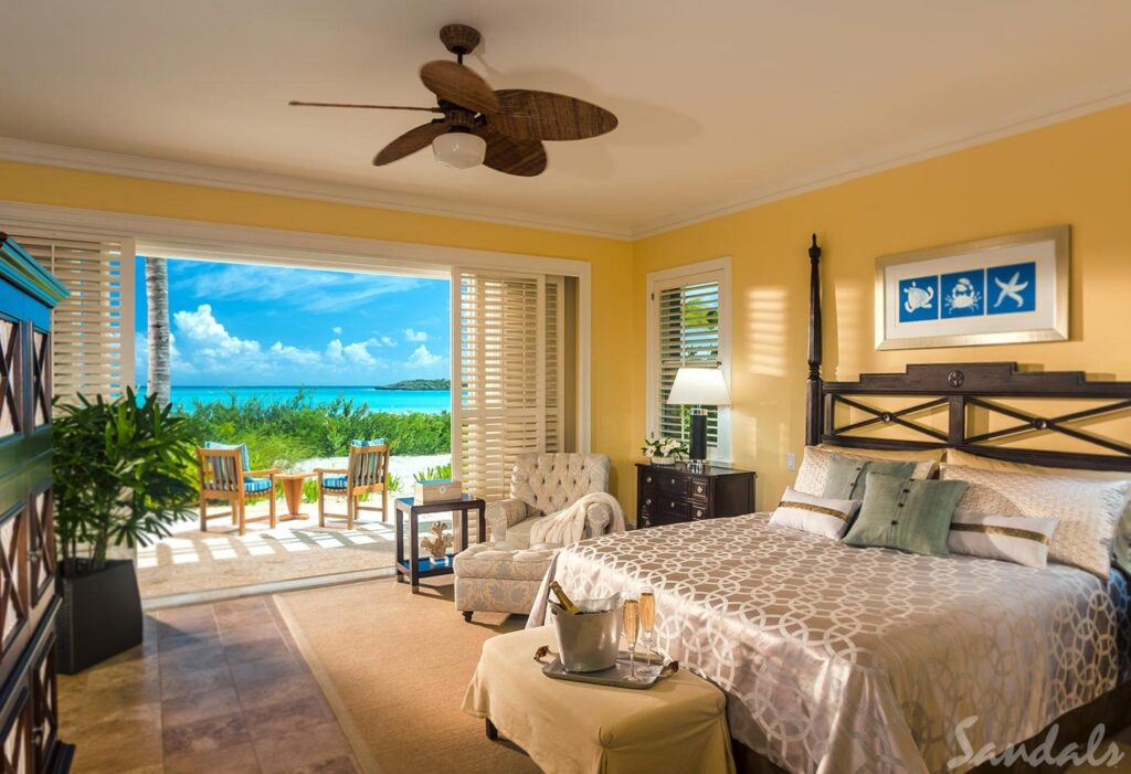 A ocean view suite in a sandals resort with a large bed.