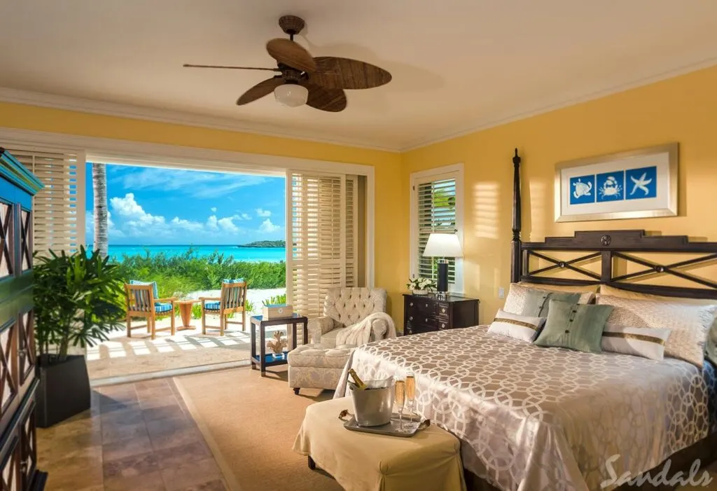A ocean view suite in a sandals resort with a large bed.