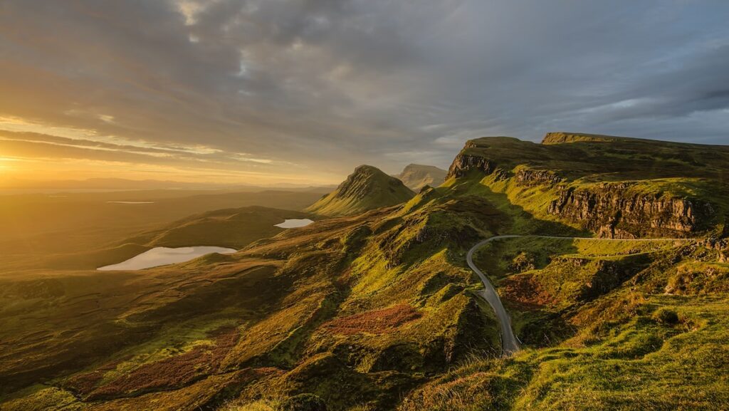 A winding road crossing steep mountains and hills on the Scotland coast.