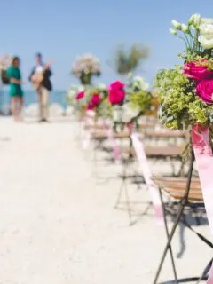 beach wedding set up with flowers on chair on beach