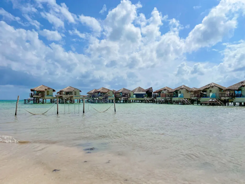 View of overwater bungalows from a beach.