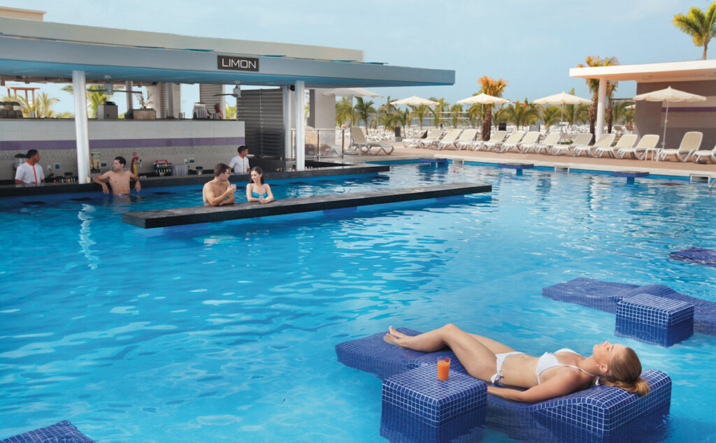 People lounging in a pool with a swim up bar.