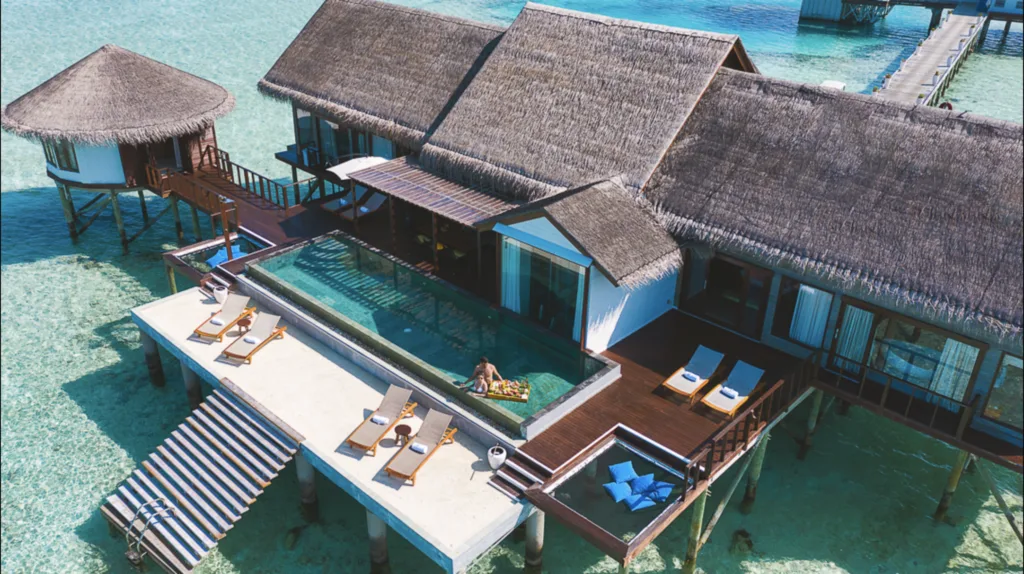 Couple in the pool of an overwater bungalow at OZEN LIFE MAADHOO in Maldives